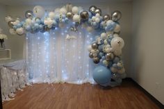 a room decorated with balloons and lights for a baby shower