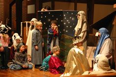 a group of children dressed up as jesus and mary in front of a nativity scene