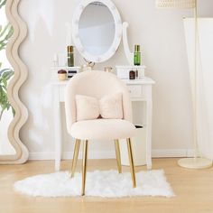 a chair with a pillow on it in front of a white desk and vanity mirror