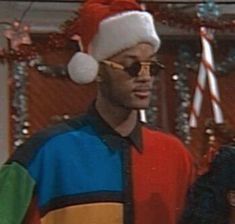 the young man is wearing a santa hat on his head and glasses in front of him