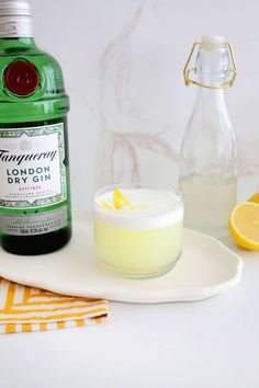 a bottle of gin next to a glass with lemonade