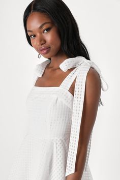 You're sure to capture plenty of hearts in the Lulus Forever Darling White Gingham Burnout Tie-Strap Mini Dress! Airy woven fabric boasts a gingham-inspired burnout fabric that shapes shoulder straps and a seamed bodice with folded trim. Fitted waist tops a circle skirt that finishes at a mini hem. Hidden zipper/clasp at side. Fit: This garment fits true to size. Length: Mid-thigh. Size medium measures 28.5" from adjustable straps to hem. Bust: Great for any cup size. Waist: Fitted - very fitted Spring Gingham Dress With Tie Straps, Summer Gingham Dress With Adjustable Straps, Chic Dress With Adjustable Straps For Picnic, Sleeveless Gingham Dress With Tie Back, Gingham Dress With Tie Straps For Day Out, Spring Gingham Dress With Tie Back, Sleeveless Gingham Dress With Tie Straps, Dress With Tie Straps, Burnout Fabric