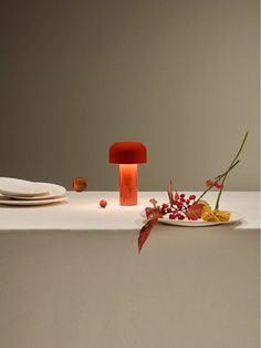 a table topped with plates and flowers next to a candle