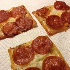 three slices of pepperoni pizza sitting on top of a white paper towel covered table