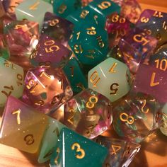 many different colored dices sitting on top of a wooden table