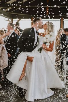 a newly married couple kissing under confetti