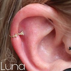 a close up of a person's ear with a piercing