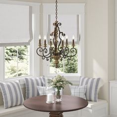 a dining room table with two chairs and a chandelier hanging from the ceiling