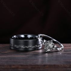 two wedding rings sitting on top of a wooden table