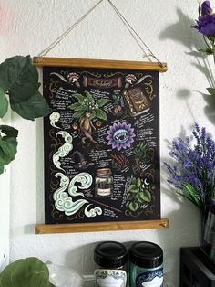 a blackboard with writing on it hanging from a wall next to flowers and plants