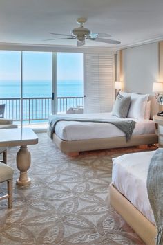 a hotel room with two beds and an ocean view