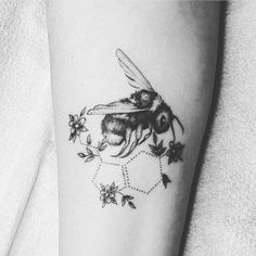 a black and white photo of a bee with flowers on it's side arm