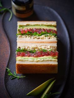 two sandwiches are sitting on a black plate