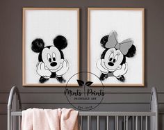 two mickey mouse pictures hanging on the wall above a crib