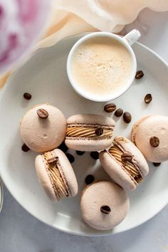 small pastries are arranged on a plate with coffee