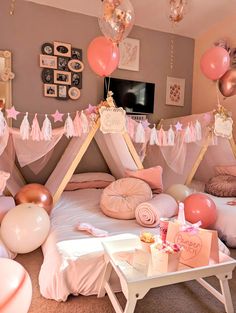 a bedroom decorated in pink and gold with balloons on the ceiling, bedding and decorations