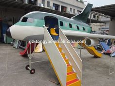 an airplane with stairs going up to the door and another plane in the back ground