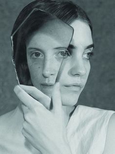 a black and white photo of a woman holding her hand to her face