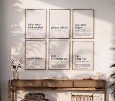 a wooden table with chairs and posters on the wall above it in front of a potted plant