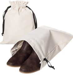 a pair of brown shoes sitting in front of a white drawstring bag on top of each other