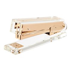 a gold and clear stapler on a white background