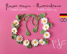 a crocheted wreath with daisies attached to it on a pink background next to the flag of germany