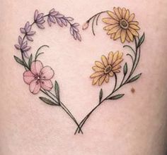 a heart shaped tattoo with flowers on it