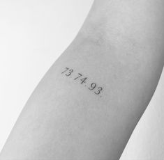 a person with a small tattoo on their arm that reads, 397 474