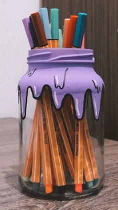 a jar filled with pencils sitting on top of a table