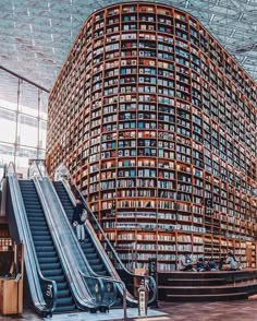 an escalator in the middle of a large library filled with lots of books