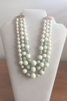 Make a fashion statement with this stunning jewelry. Fun, unique necklace from the past.  This white Faceted Beads triple Strand necklace has hints of green on some of the beads. A fun addition to your spring wardrobe. Lucite Plastic Beaded Necklace. Measures 13 inches long, plus a 3 inch extension. Has an elegant hook closure. Excellent Condition. Please see photos. 2023-01 Luxury White Oval Beaded Necklaces, White Multi-strand Costume Jewelry Necklace, White Costume Jewelry With Colorful Beads, Vintage White Multi-strand Beaded Necklaces, White Double Strand Faceted Beads Necklace, Vintage White Necklaces With Large Beads, White Double Strand Beaded Necklace With Colorful Beads, White Double Strand Necklace With Colorful Beads, Vintage Double Strand White Jewelry