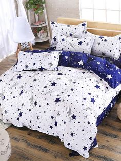 a bed with blue and white stars on the comforter, pillows and pillow cases