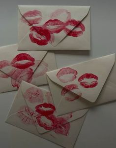 four envelopes with red lipstick prints on them