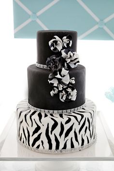 a three tiered cake with black and white designs