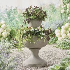 three planters are stacked on top of each other in the middle of a garden