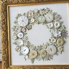 a framed picture with buttons and flowers on the bottom, surrounded by other button pieces