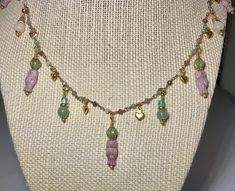 This dainty necklace is a unique Czech glass owl beaded charm necklace. The owls and dangle charms are in shades of purple, green, aqua, and blue, and are interspersed with tiny gold hearts. The chain is made up of purple, pink, green, and aqua beads. The necklace is adjustable from 16 to 18 inches. It is a must for owl lovers! Handmade Adjustable Whimsical Charm Necklace, Czech Glass Dangle Necklaces As Gift, Spiritual Beaded Necklaces With Dangling Beads As Gift, Bohemian Crystal Necklaces For Gift, Beaded Charm Dangle Necklaces As A Gift, Bohemian Gemstone Beads Charm Necklaces As Gift, Czech Glass Dangle Necklaces With Dangling Beads, Beaded Dangle Charm Necklaces For Gifts, Dangle Charms Beaded Necklace For Gift