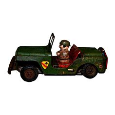 a green toy truck with a stuffed animal in the back