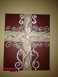 a cross made out of paper with white swirls on the center and red background