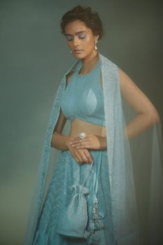 Ice blue lehenga in organza embroidered with dori work. Paired with blouse and net dupatta with embroidered border.
Component: 3
Embroidered
Neckline: Halter
Sleeve Length: Sleeveless
Fabric: Organza, Soft Net; Lining: Dupion Silk, Cotton Shantoon
Color: Blue
Dori embroidery work
Back cut-out blouse
Side tassel tie lehenga
Closure:
Blouse: Back closure with hook and eye on neck and hem 
Lehenga: Side zip closure
Note: The potli bag carried by the model is not for sale - Aza Fashions Net Dupatta Sets For Reception, Anarkali Sets For Reception In Net, Reception Net Sets With Dupatta, Designer Choli With Sheer Dupatta, Floor-length Net Sets For Reception, Designer Net Lehenga With Sheer Dupatta, Elegant Net Choli With Traditional Drape, Net Saree Gown For Reception, Reception Net Choli With Traditional Drape