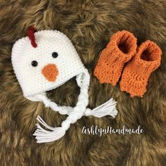 a crocheted chicken hat and booties are laying on a furry surface