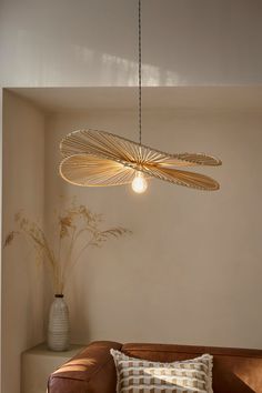 a living room filled with furniture and a light fixture hanging from the ceiling above it