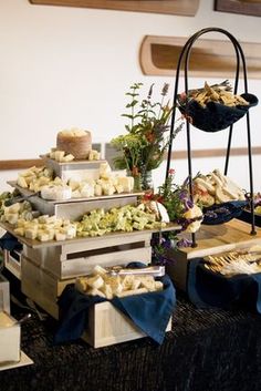 an assortment of food is displayed on a table with blue cloths and napkins