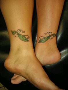 two people with tattoos on their feet sitting next to each other, one has a leaf and the other has a vine