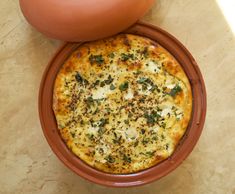 a pizza sitting on top of a brown plate next to a potted plant