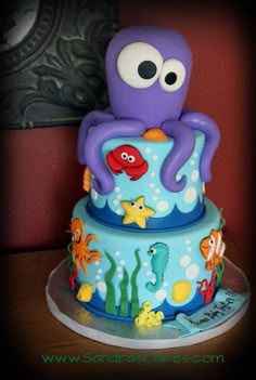 an octopus cake is decorated with blue icing and under the sea animals on it