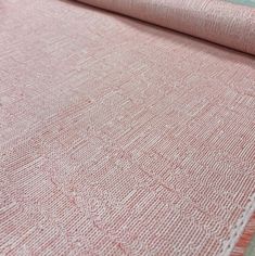 a close up view of a pink rug with white trimmings on the edge