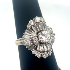 * Estate 14k White Gold Round Diamond Center Waterfall Wave Accented Cocktail Ring * Ring Size: 7.0 * Top Of Ring Measures: 7/8" X 5/8" * Height: 1/2" * Band Width: 2.05 Mm * Round Diamond Measures Approximately 5.6 Mm * Twenty-Six Baguette Diamonds Measure Approximately 3.0 Mm X 1.3 Mm X .95 Mm Each * Two Round Diamonds Measure Approximately 3.1 Mm Each * Six Round Diamonds Measure Approximately 2.25 Mm Each * Eight Round Diamonds Measure Approximately 1.6 Mm Each * Ring Weight: 6.3 Tgw * Marke Antique Jewelry Rings, Baguette Diamonds, Baguette Diamond, Ring Ring, Ring Size 7, Cocktail Ring, Cocktail Rings, Womens Jewelry Rings, Rings Statement