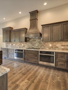 a kitchen with wooden cabinets and stainless steel stove top oven, range hood and microwave