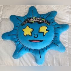 a blue pillow with a crown on it's head sitting on top of a bed